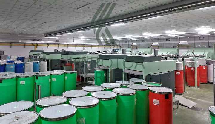 Karotoa Green modern spinning mill interior with automated textile machines and yarn storage drums.