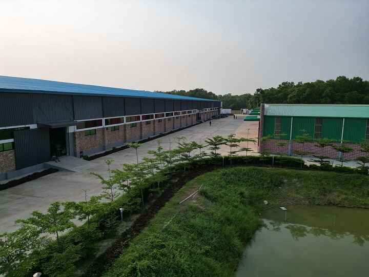 Karotoa Green manufacturing complex with factory buildings, greenery, and water reservoir.