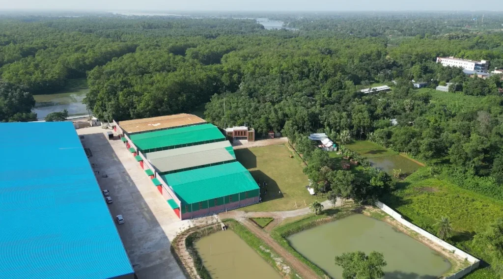 Drone view of Karotoa Green manufacturing facility featuring green-roofed buildings, water reservoirs, and extensive greenery.