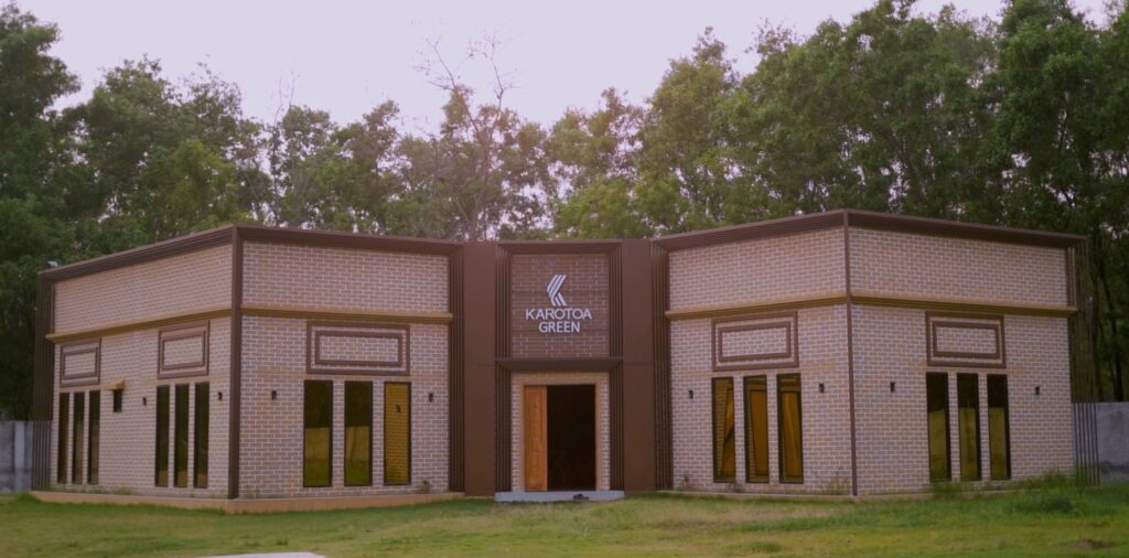 Karotoa Green modern brick guest house building surrounded by greenery.