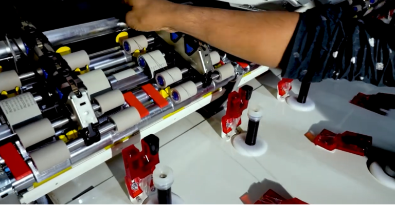 Technician operating automated yarn processing machine at Karotoa Green spinning mill.